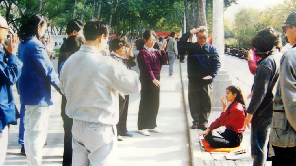 Volonter podučava prolaznike Falun Gong meditaciji na ulici